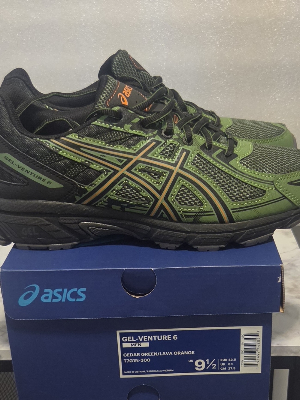 Asics men's athletic shoe in cedar green with lava orange accents